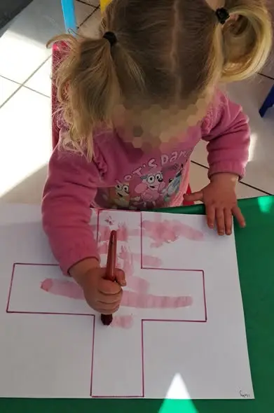 A little artist drawing a cross